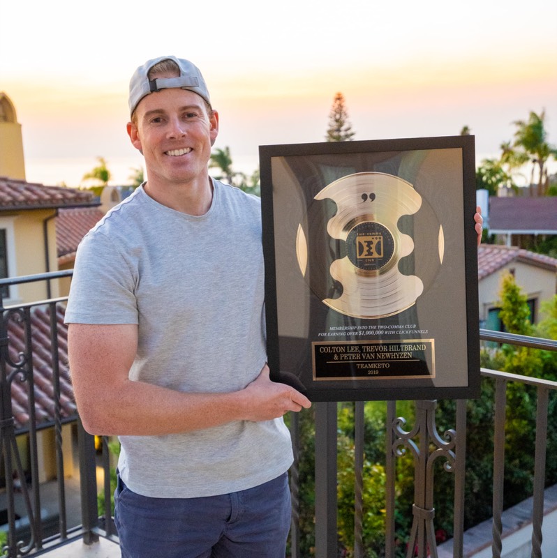 Colton Lee holding Two Comma Club Award